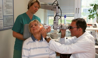Chefarzt bei der Untersuchtung der Ohren einer Patientin