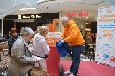 Auf dem Bild werden mehrere Personen gezeigt die sich an einem Gutscheingewinnspiel beteiligem.