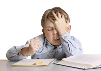 Schulkind sitzt nachdenklich über den Schulbüchern