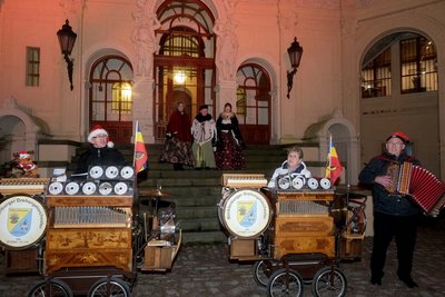 Männer und Frauen im Schlossinnenhof mit ihren Drehorgeln.