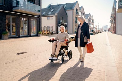 Zwei ältere Frauen, davon eine im Rollstuhl "erivo"